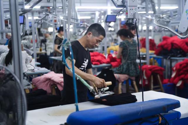 在佛山的服装工厂，工人正在生产童装。（受访者供图）