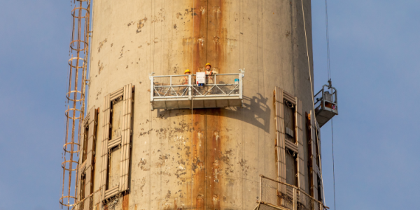 大烟囱上工人正在吊篮当中进行高空施工沈国栋 2023年3月15日拍摄